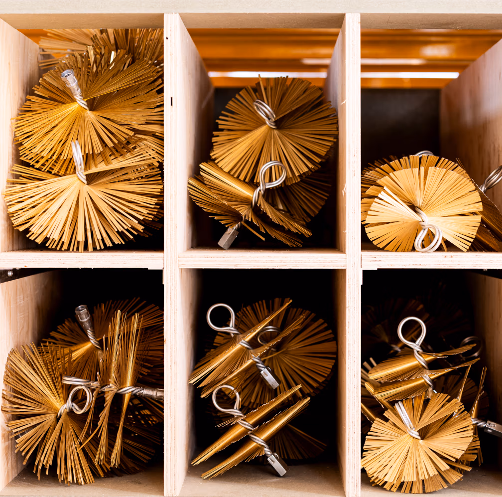 Bundels stro of houten stokjes die met metaaldraad zijn vastgebonden, zijn netjes gerangschikt in een houten cubby-achtige plank, van bovenaf gezien - perfect als haardaccessoires als aanvulling op het decor van je open haard.