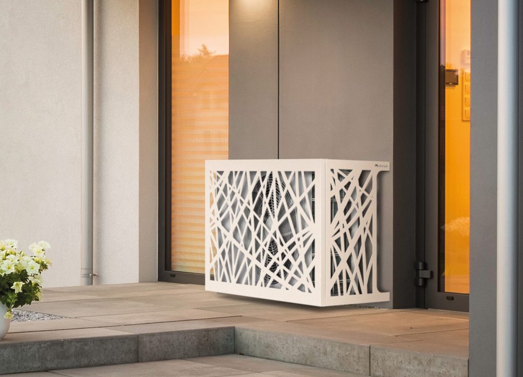 A modern white decorative cover with an abstract, crisscross pattern—reminiscent of trendy wholesale hair accessories—conceals an outdoor unit next to a glass door and beige wall on a tiled patio.
