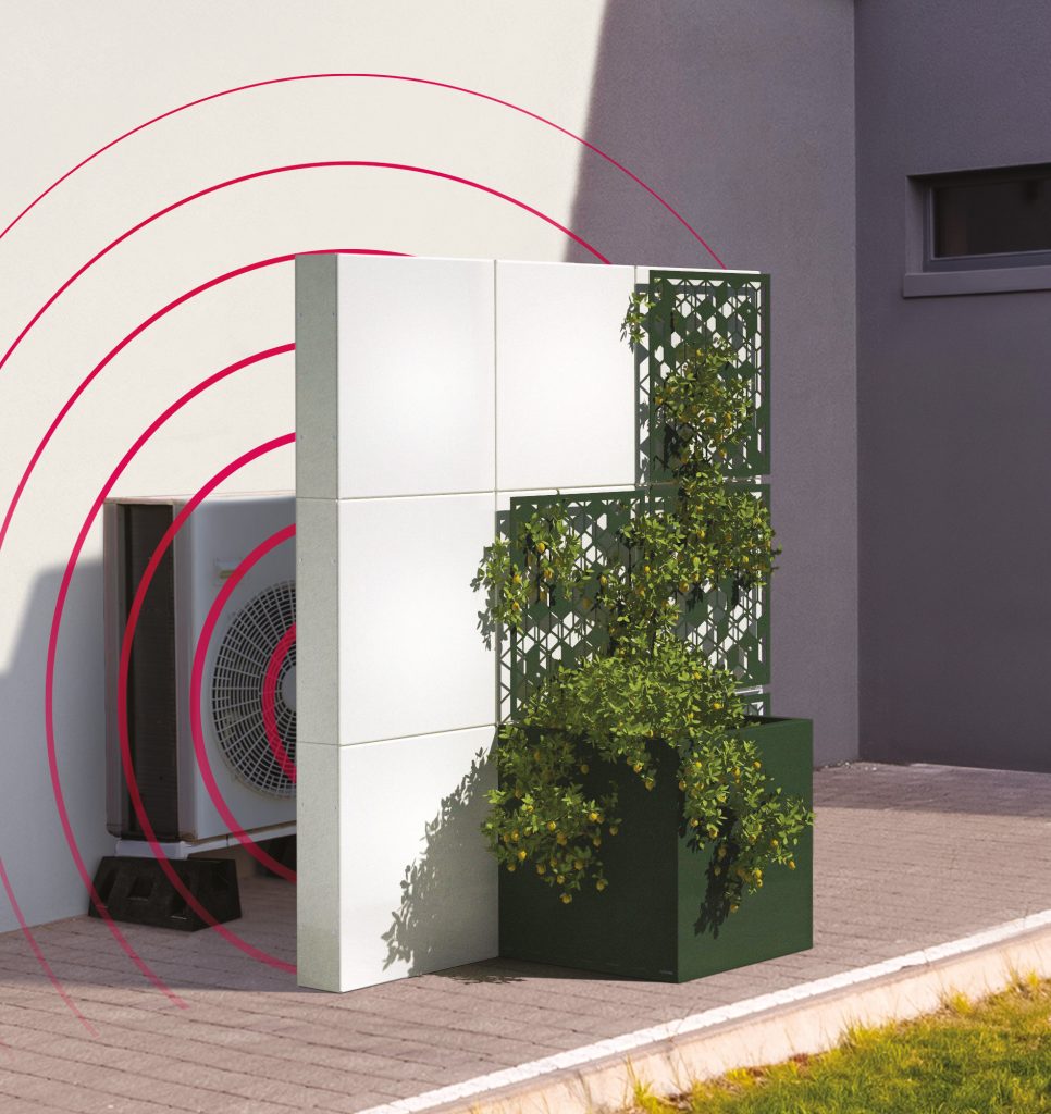 A heat pump unit is partially hidden behind a decorative white and green panel with plants growing in front; red radiating lines illustrate sound waves coming from the unit, highlighting the importance of PRO installation materials for effective noise reduction.